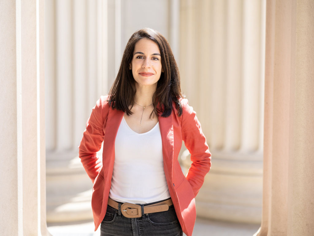 Portrait photo of of Juncal Arbelaiz Mugica standing among large columns on the MIT campus