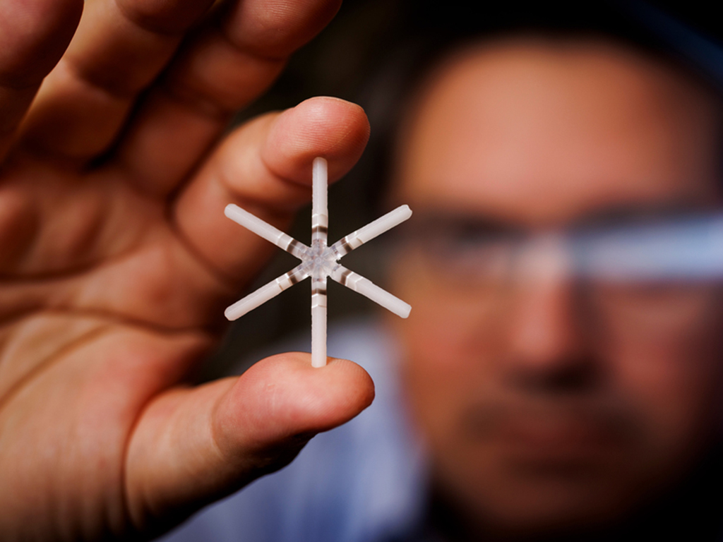 Hand holding very tiny intersecting tubes